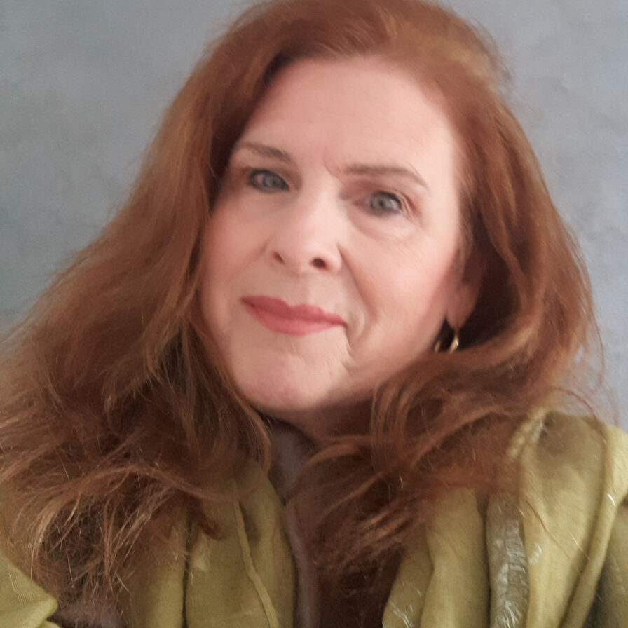 A woman with red hair and wearing a green jacket.